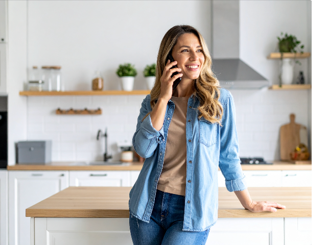 A homeowner speaking on the phone in her kitchen.