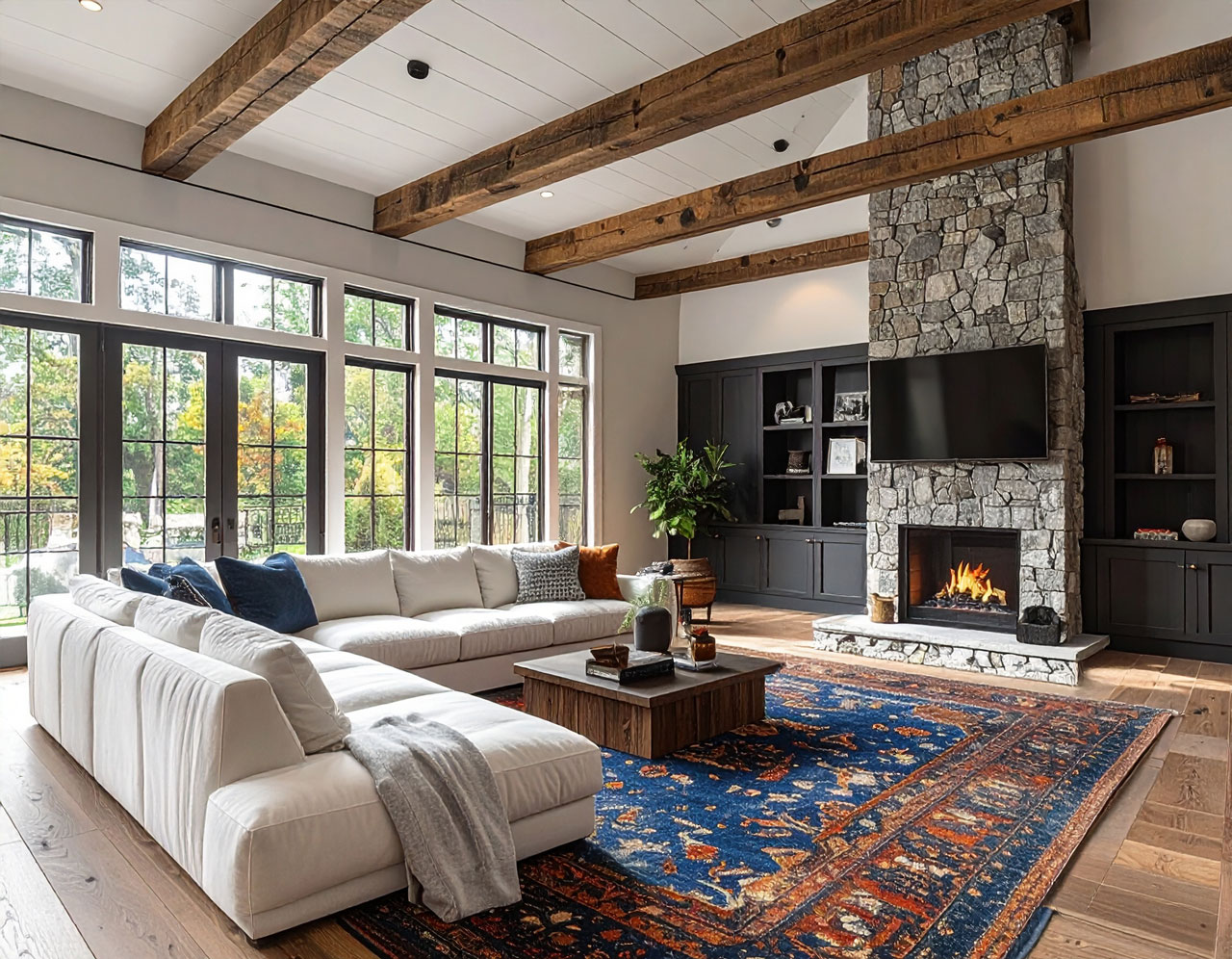 A well-cared-for living room with a stone fireplace, built-ins, and exposed ceiling beams.